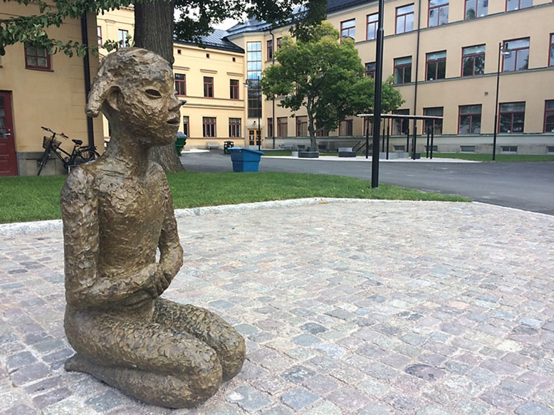 bild på bronsskulptur av lena cronqvist föreställande flicka som sitter på knä
