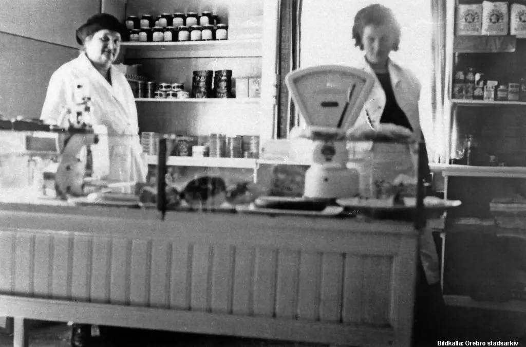 Två kvinnor står bakom en disk i en affär.