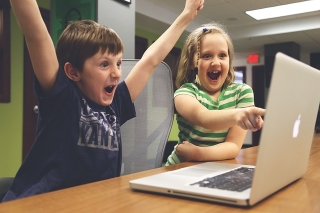 Glada barn vid en dator